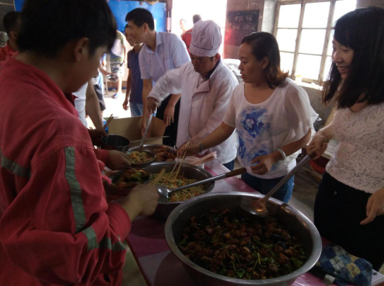 公司領(lǐng)導為員工們盛飯